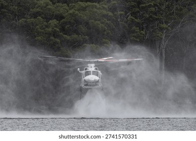 Fire fighting helicopter hovering over water