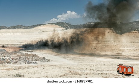 Fire Fighting In A Tire Dump. Fire Truck And Black Smoke From Burning Tires