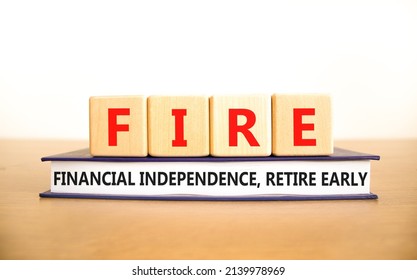 FIRE financial independence retire early symbol. Concept words FIRE financial independence retire early on cubes on book. White background. Business FIRE financial independence retire early concept.