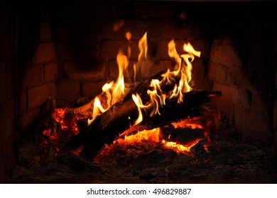 fire in fireplace/ brick fireplace with burning firewood in it.