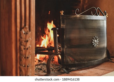 Fire in a french old fireplace with a fire shield