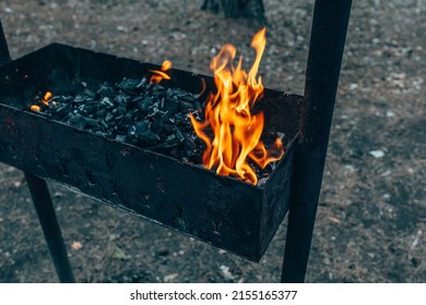 Fire in the grill. Outdoor recreation. Cooking outside on an open fire. Burning coals.