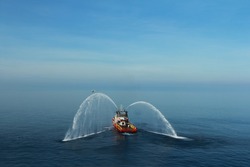 Fire Hose Boat Is Spraying Water On The Sea For Supporting Emergency Case Of Fire Of Offshore Oil And Gas Industry. Fire Fighting Boat Sprays Water On The Sea.
