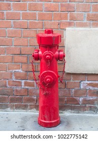 fire hydrant or fireplug  connection for firefighters in public road for water supply next to a brick wall
