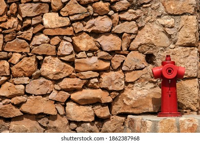 Fire hydrant next to the stone wall in Alquezar, a small town of Huesca.