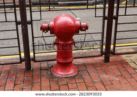 Fire hydrant on wet sidewalk in Hong Kong street.