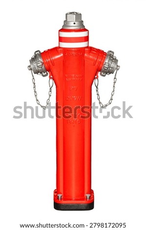 A fire hydrant is placed on a sidewalk in an urban area. The hydrant is bright red with metal connectors and chains. The sun is out and the sky is clear.