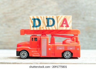 Fire ladder truck hold letter block in word DDA (Abbreviation of Depreciation, depletion and amortization or demand deposit account) on wood background