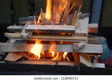 A fire is lit on the wood prepared for him. Several pine and birch logs are stacked in a square tower in the center of which sawdust and wood chips begin to flare up.