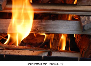 A fire is lit on the wood prepared for him. Several pine and birch logs are stacked in a square tower in the center of which sawdust and wood chips begin to flare up.