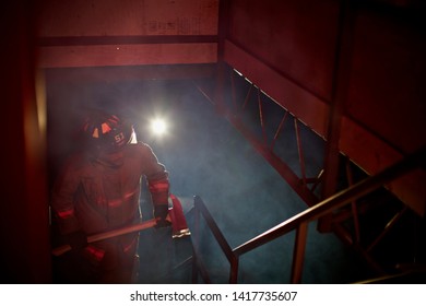 Fire Man Going Up Stairs In Smokey Building Looking For Survivors