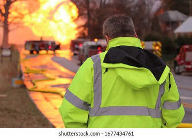 Fire Official Monitors Progress Of The Firefighting Crews Attempting To Extinguish A Gas Line Eruption From A Safe Distance