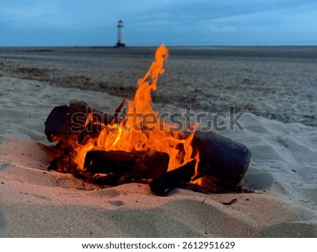 Fire on the beach overlooking lighthouse 