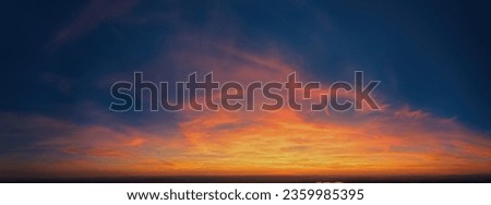 Fire on the sky: Aerial, long panoramic view of colorful, orange and red colored streakes of cirrus clouds on deep blue evening sky.  Ideal for sky replacement projects, no obstacles in the front. 