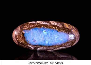 Fire Opal between a bedrock, black background, mineral gemstone, healing stone