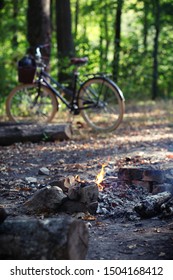 Fire outdoor in autumn park with bicycle on backstage