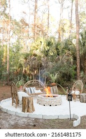 Fire Pit Bonfire Campsite In Tropical Backyard Woods With Rustic Wooden Branch Chairs Twinkle Lights Lantern Candles Palm Trees Stump Tables In Florida At Sunset