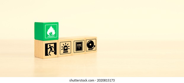 Fire prevention, Close-up cube wooden toy block stack with prevent icon with door exit sing or fire escape with fire extinguisher and emergency protection symbol for safety and rescue in the building.