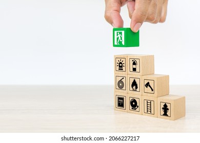 Fire prevention, Hand choose cube wooden block stack door exit sing or fire escape with prevent icon and fire extinguisher and emergency protection symbol for safety and rescue in the building. - Shutterstock ID 2066227217