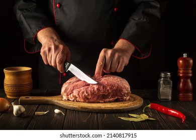 For Fire, Raw Meat Must Be Cut Into Small Pieces. Hands Of A Chef With A Knife In The Kitchen. Cooking Delicious Food For A Restaurant.