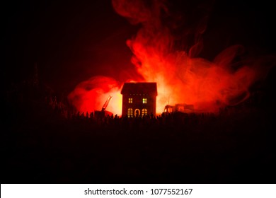 Fire Safety Concept. Huge Flame Distracting House On Fire. Fire Engine With Ladder And Fireman Trying To Save House. Fireman At Work. Silhouettes Of A Large Crowd Of People Watching At Fire At Night.