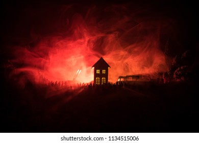 Fire Safety Concept. Huge Flame Distracting House On Fire. Fire Engine With Ladder And Fireman Trying To Save House. Fireman At Work. Silhouettes Of A Large Crowd Of People Watching At Fire At Night.