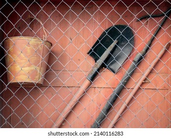 Fire Shield Of Primary Fire Extinguishing Means. And A Tool Used In The Elimination Of Small Fires And Fires In The Initial Stage. Bayonet Shovel, Hook, Crowbar And Bucket Behind The Net.