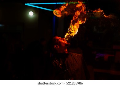 Fire show. Creative fiery artist, artist of extreme fire show show their skills and let firestorm of mouth, blows and breathes fire. Artist blowing fire from his mouth - Shutterstock ID 521285986