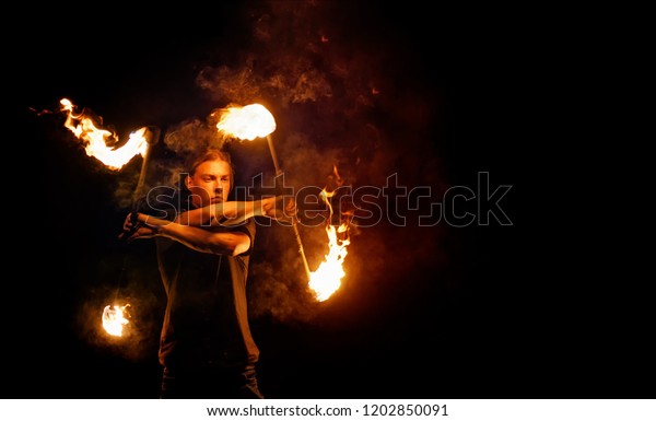 Fire show. Fire dancer dances\
with. Night performance. Dramatic portrait. Fire and\
smoke.