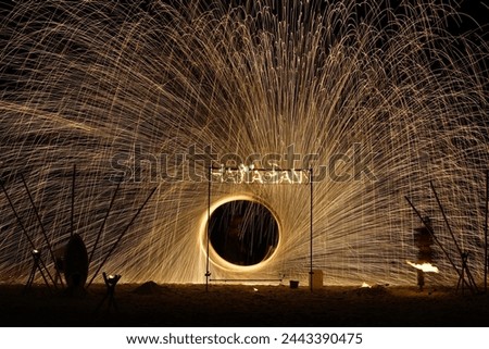 Fire show on the beach at night. Radius of sparkling light during the night show