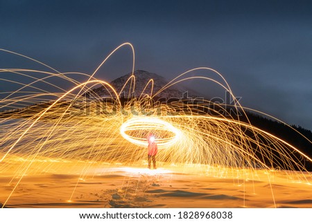 Fire show with lot of sparks in night winter mountains. Landscape photography