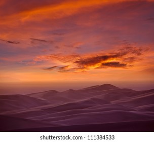 Fire in the sky and the glowing ribbons of light over the dusky hills of Colorado Great Sand Dunes. - Powered by Shutterstock