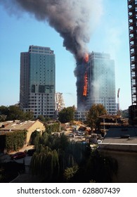Fire  and smoke blaze from residential 
 apartment. Civilian high-rise building damaged from enemy rocket attack.