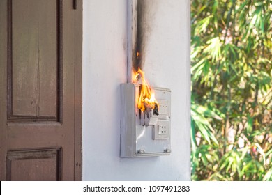 Fire And Smoke Burning On Electric Wire Plug, Electric Short Circuit Causing Fire On Plug Socket. Over Using Electricity Power From Too Many Electrical Devices