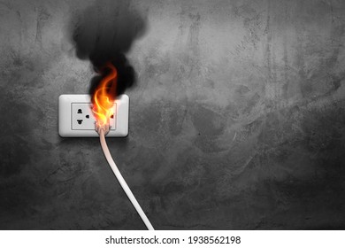 Fire and smoke on electric wire plug in an indoor, electric short circuit causing fire on plug socket, old power plug, damaged power plug, short circuitม, danger of fire