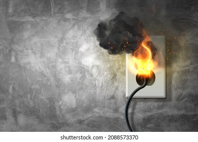 Fire and smoke on electric wire plug in an indoor, electric short circuit causing fire on plug socket, old power plug, damaged power plug, short circuit.