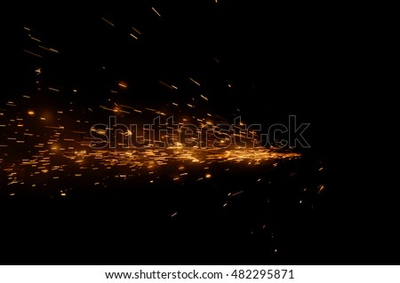 Fire sparks on a black background during metal cutting, hot burning element in flame 