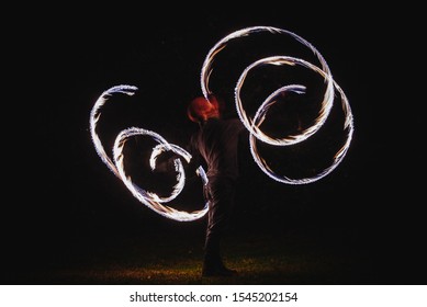 Fire Spinner Making Different Figures With Fire. Slow Motion Image. Fire Spinning