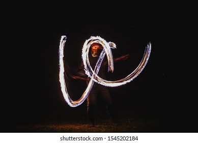 Fire Spinner Making Different Figures With Fire. Slow Motion Image