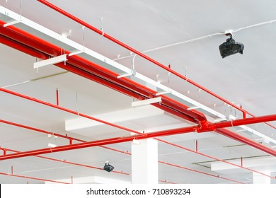 Fire Sprinkler System With Red Pipes Is Placed To Hanging From The Ceiling Inside Of An Unfinished New Building.