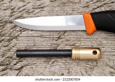 
Fire Starter And Camping Folding Knife On Grungy Wooden Background   