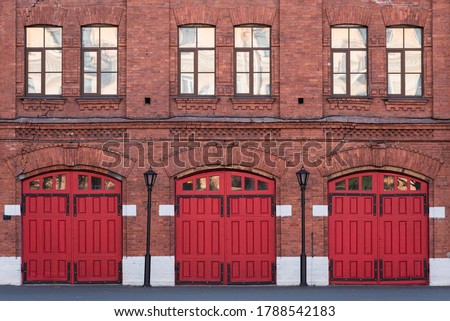 Fire station, an old historic brick building (1880s) with red gates. Fire department in Vasilyevsky Island, St. Petersburg, Russia.