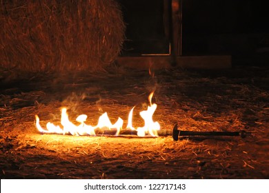 Fire sword burning on the ground with straw