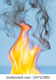 Fire And Thick Black Smoke On A Light Blue Background