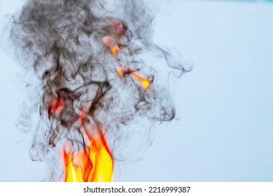 Fire And Thick Black Smoke On A Light Blue Background