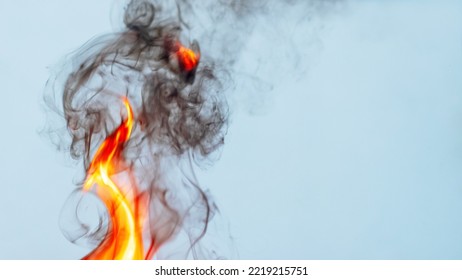 Fire And Thick Black Smoke On A Light Blue Background