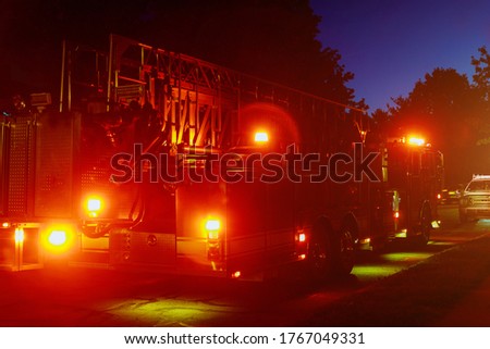 Fire truck with flashing red lights of a fire engine night time in dusk