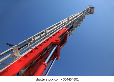 Fire Truck Ladder Leading Up Into Blue Sky.