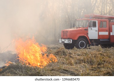 Fire Truck Near Burning Grass In Countryside Has Come To Put Out A Wild Fire