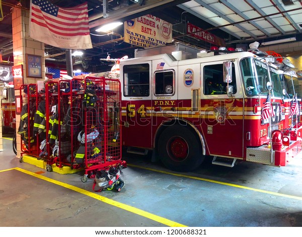 Fire truck in the parking lot in FDNY Engine\
54 Ladder 4 Battalion 9 on 8th Avenue in Midtown New York, waiting\
for a call. F.D.N.Y. firetrucks parked inside a station. New York,\
USA 10/01/2018